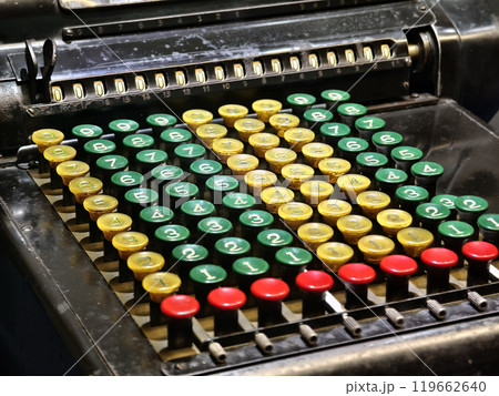An old fashioned adding machine features a drawer located underneath it 119662640