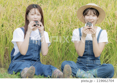 稲刈りの途中で休憩をしている若い女性達 稲刈りの途中で休憩をしている若い女性達 119662704
