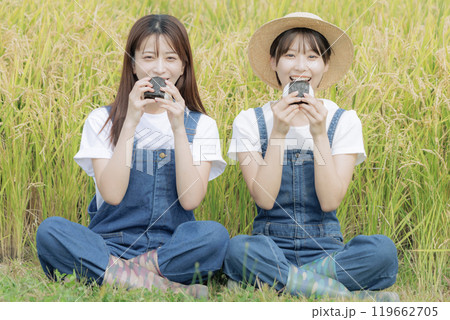 稲刈りの途中で休憩をしている若い女性達 稲刈りの途中で休憩をしている若い女性達 119662705