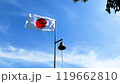 風になびく日本の国旗と鐘 119662810