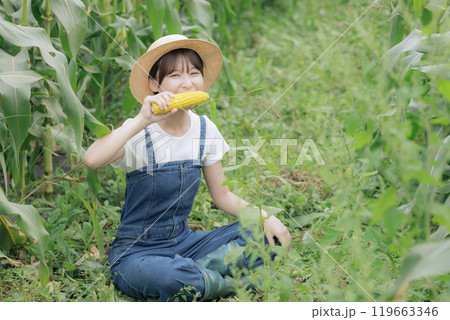 収穫したばかりの野菜を食べる若い女性 収穫したばかりの野菜を食べる若い女性 119663346