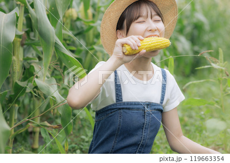 収穫したばかりの野菜を食べる若い女性 119663354