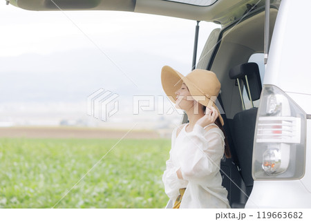 トランクに座り休憩をしている若い女性 トランクに座り休憩をしている若い女性 119663682