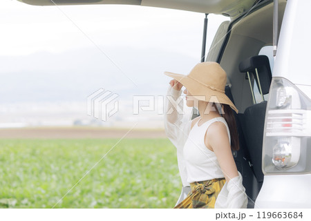トランクに座り休憩をしている若い女性 119663684