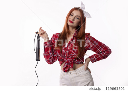 A Stylish Woman Dressed in a Bright Red Checkered Shirt While Using Her Hair Iron 119663801