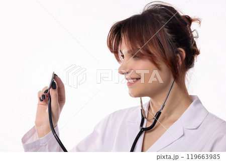 A Young Female Doctor, Holding a Stethoscope with a Bright Smile, Radiates Assurance and Care A Young Female Doctor, Holding a Stethoscope with a Bright Smile, Radiates Assurance and Care 119663985