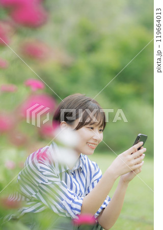 座ってスマホを弄る若い女性 119664013