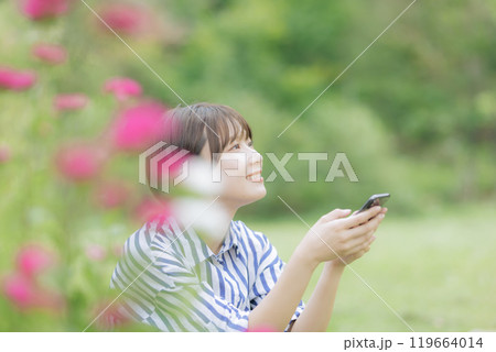 座ってスマホを弄る若い女性 座ってスマホを弄る若い女性 119664014