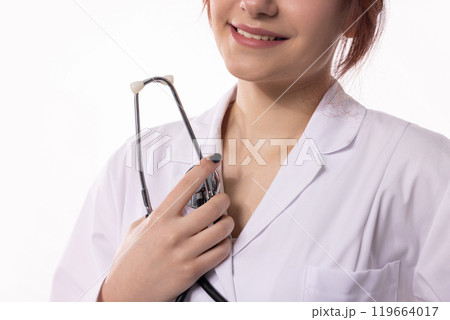 A Female Healthcare Professional proudly holding a Stethoscope in her work environment A Female Healthcare Professional proudly holding a Stethoscope in her work environment 119664017