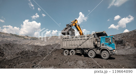 Large quarry dump excavator. Big yellow mining excavator at work site. Loading coal into body truck. Mining digger, mining machinery to loading rock. Production useful minerals 119664890