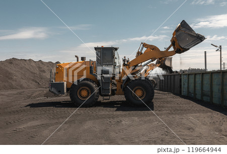 Loading of an loader into railway wagons. Excavator loading coal into wagons. Loading of coal truck using excavator. Shipment coal for transportation by rail Loading of an loader into railway wagons. Excavator loading coal into wagons. Loading of coal truck using excavator. Shipment coal for transportation by rail 119664944