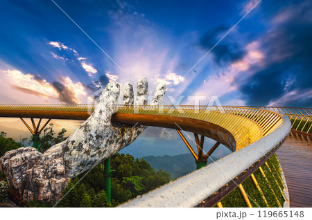 Beautiful Golden Bridge or Hand of Gods at the Ba Na Hills amusement Park in Da Nang in Vietnam on mountain at sunset in summer Beautiful Golden Bridge or Hand of Gods at the Ba Na Hills amusement Park in Da Nang in Vietnam on mountain at sunset in summer 119665148