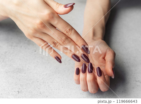 Elegant hands with almond-shaped maroon nails Elegant hands with almond-shaped maroon nails 119666643