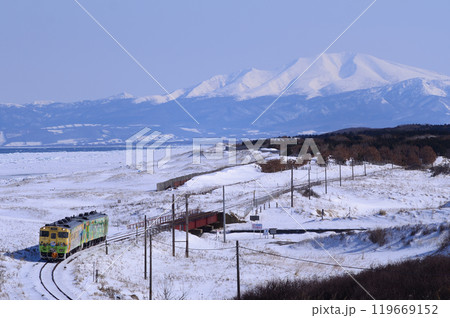 流氷が押し寄せたオホーツク海と海別岳をバックに網走駅へ向かう「流氷物語」号 119669152