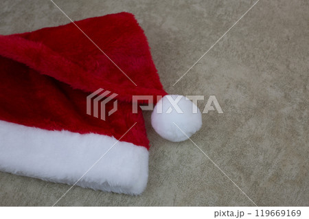 Furry red cap for New Year lies on light background Furry red cap for New Year lies on light background 119669169