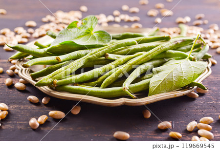 Heap of green pods of raw, not cooked, asparagus beans and white beans on a table Heap of green pods of raw, not cooked, asparagus beans and white beans on a table 119669545