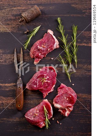 raw beaf on a dark wooden table. 119669554