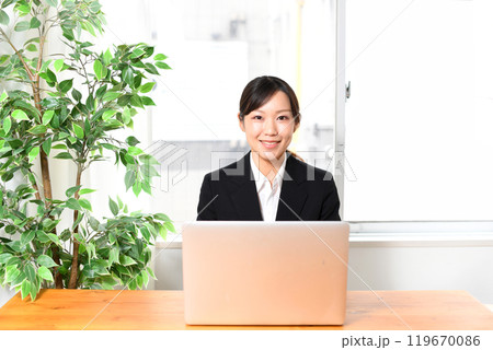 ノートパソコンを使うスーツ姿の若い女性 ノートパソコンを使うスーツ姿の若い女性 119670086