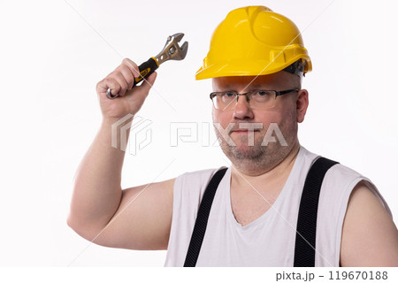 A Construction Worker Holding a Wrench, Wearing a Bright Yellow Hard Hat and Smiling A Construction Worker Holding a Wrench, Wearing a Bright Yellow Hard Hat and Smiling 119670188