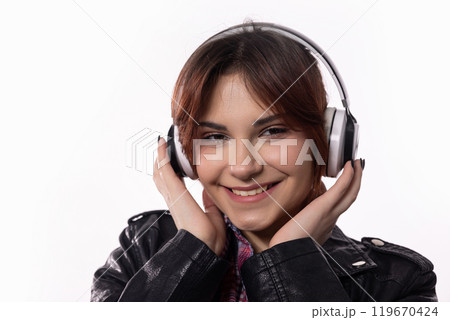 A Joyful Girl Happily Enjoying Her Favorite Music While Wearing Headphones and Smiling A Joyful Girl Happily Enjoying Her Favorite Music While Wearing Headphones and Smiling 119670424