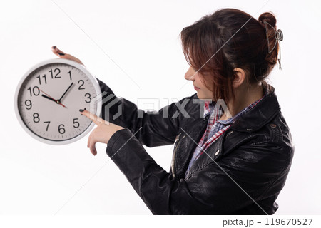 A woman is pointing at a clock which symbolizes the important concept of time management A woman is pointing at a clock which symbolizes the important concept of time management 119670527