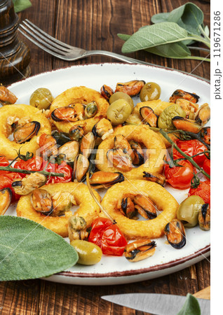 Grilled mussels with herbs and squid rings. Grilled mussels with herbs and squid rings. 119671286