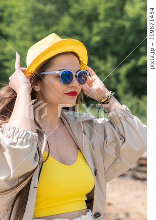 Meeting with the unknown: in a yellow robe, woman looks as if she is preparing to make important journey. Fulfillment of dreams: her cheerful mood symbolizes the endless possibilities that lie ahead. 119671434