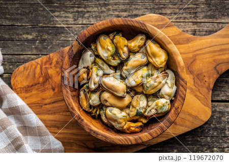Shelled mussels meat in bowl on wooden table. Top view. 119672070