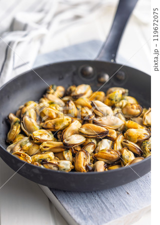 Shelled mussels meat in pan on white table Shelled mussels meat in pan on white table 119672075