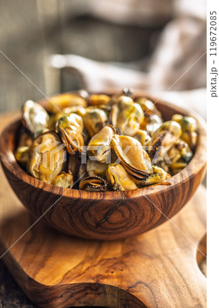 Shelled mussels meat in bowl on wooden table. Shelled mussels meat in bowl on wooden table. 119672085