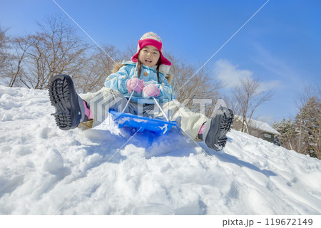雪の公園でソリ遊びをする女の子 119672149