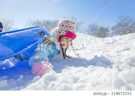雪の公園でソリ遊びをする女の子 119672151