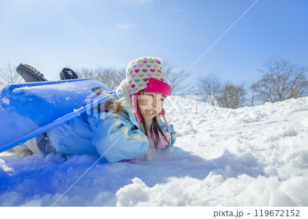 雪の公園でソリ遊びをする女の子 119672152