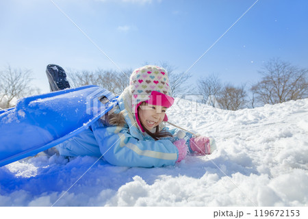 雪の公園でソリ遊びをする女の子 119672153