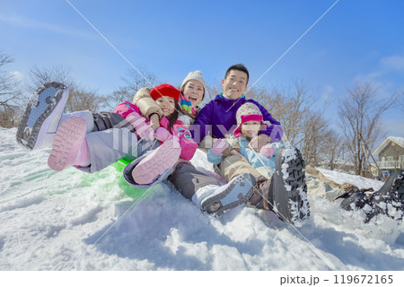 雪の公園でソリ遊びをする4人家族 119672165
