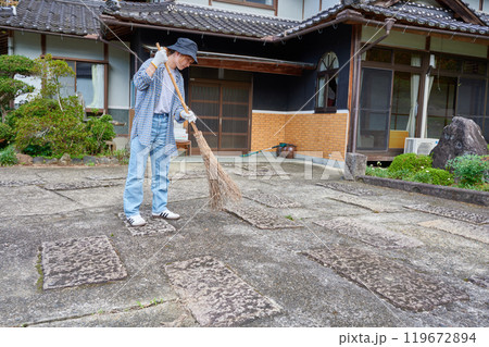 庭を掃き掃除する女性　田舎　古民家　旅館　暮らし 119672894