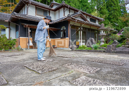 庭を掃き掃除する女性　田舎　古民家　旅館　暮らし 119672899