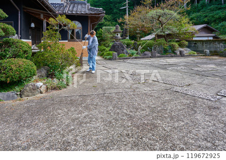 庭を掃き掃除する女性　田舎　古民家　旅館　暮らし 119672925