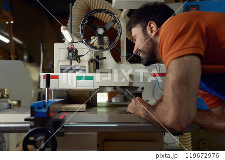 Woodworker using planer machine for production wooden materials specific size Woodworker using planer machine for production wooden materials specific size 119672976