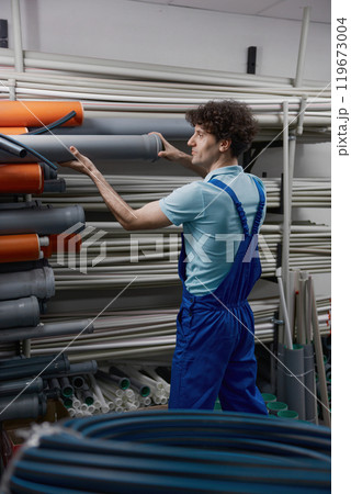 Man plumber choosing supplies for pipework at plumbing shop Man plumber choosing supplies for pipework at plumbing shop 119673004