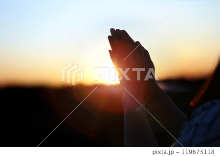New Year sunrise rising sun background and shining light through praying christian hands, future hope and wish concept New Year sunrise rising sun background and shining light through praying christian hands, future hope and wish concept 119673118