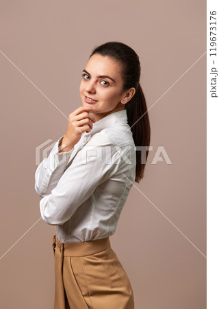 caucasian businesswoman lady with crossed arms in white shirt and beige pants 119673176