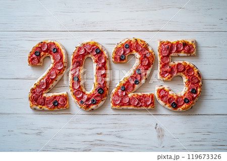 Overhead of pepperoni pizza number of year on white wooden surface, New Year holiday background with edible numbers 2025 119673326