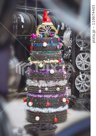 A creative Christmas tree made from tires at an auto shop is a festive and ecofriendly decoration A creative Christmas tree made from tires at an auto shop is a festive and ecofriendly decoration 119674405