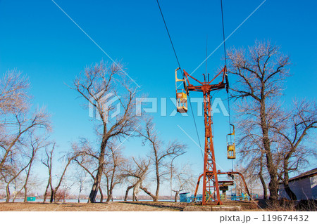 Old cable car in Dnepropetrovsk. Cable car cabins against the background of the blue sky and the urban landscape. Old cable car in Dnepropetrovsk. Cable car cabins against the background of the blue sky and the urban landscape. 119674432