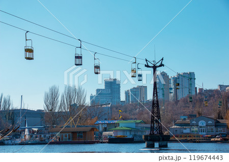 Old cable car in Dnepropetrovsk. Cable car cabins against the background of the blue sky and the urban landscape. 119674443