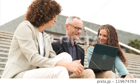 Confident businesspeople using netbook on steps during daytime Confident businesspeople using netbook on steps during daytime 119674763