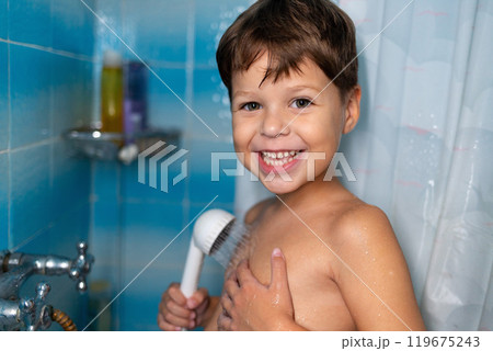 A child smiles while taking a shower. 119675243