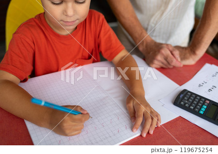 A six-year-old boy with dysgraphia and dyscalculia does his math homework. 119675254