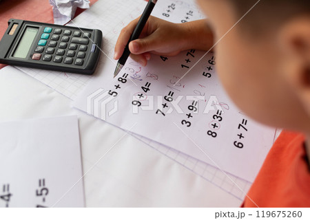 Over the shoulder view of a child who has dyslexia and dyscalculia doing math homework. 119675260